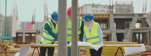 Construction Workers Reviewing Plans at Construction Site