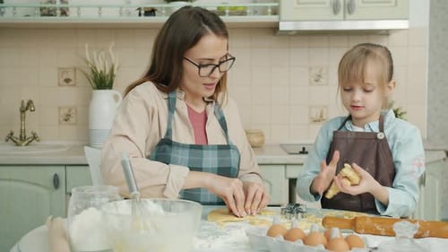 Mother and Child Baking Cookies in Kitchen