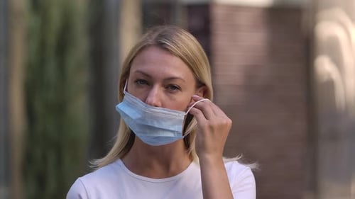 Woman Puts on a Surgical Mask, Close Up