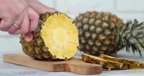 Pineapple Being Cut on Wooden Cutting Board