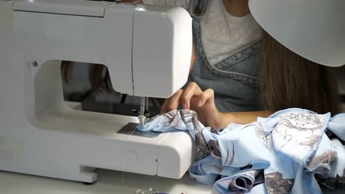 Seamstress Works at Sewing Machine Makes Straight Seams on Cloth Hands Closeup