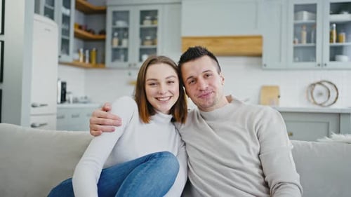 Affectionate Young Couple Relaxing on Sofa at Home