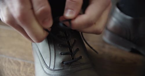 Man Tying Shoelaces of Brown Leather Dress Shoe