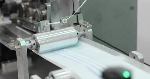 Machine Reel Pressing Folded Pleats Of Surgical Mask. close up, rotating shot