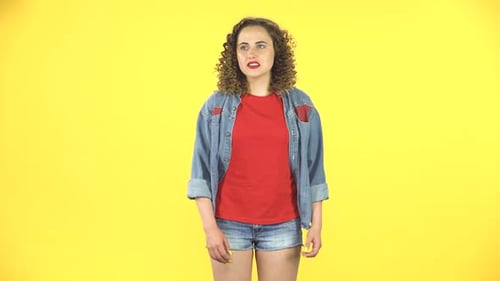 Mujer rizada se siente muy mal, le duele el estómago sobre fondo amarillo en el estudio