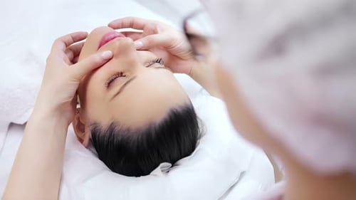 Woman Receiving Relaxing Facial Massage at Spa