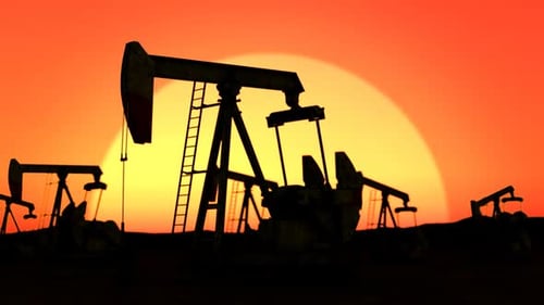 Silhouette of oil pumps pumping the crude oil into pipelines at the desert.