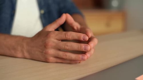 Closeup Hands of Unrecognizable Young Man Nervously Tapping Fingertips Against Each Other Sitting at