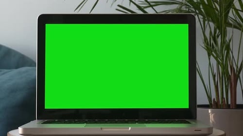 Laptop with Green Screen Display in Home Setting