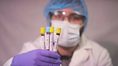 Medical Professional Holds COVID-19 Test Vials