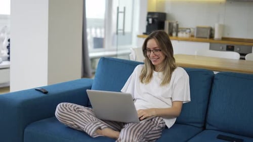 Young Woman Video Chatting on Laptop at Home
