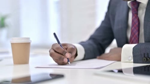 Close Up of African Businessman Doing Paperwork