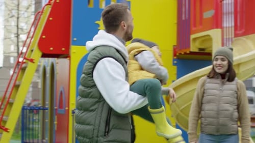 Un père et un fils caucasiens aimants tournent ensemble sur une aire de jeux