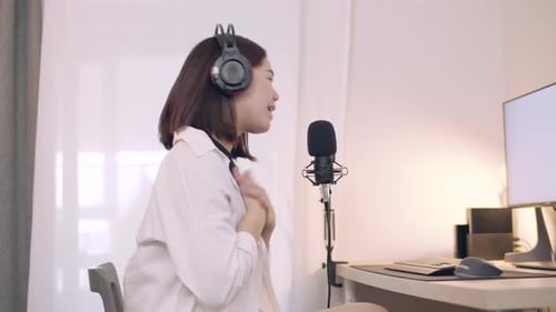 Woman Recording Audio with Microphone at Desk