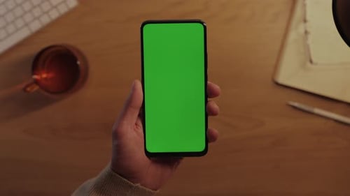 Close Up of Male Hands Tapping on Green Screen of Mobile