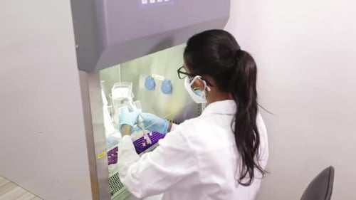 Female Scientist Working with Test Tubes in Sterilized Lab