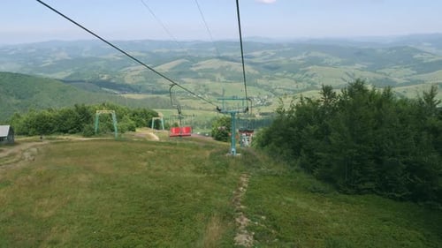 Open Chairlift Ascends Green Mountain on Sunny Day