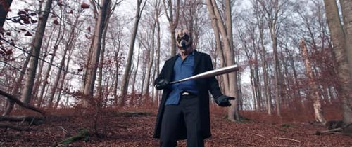 Masked Figure Wielding Bat in Eerie Forest