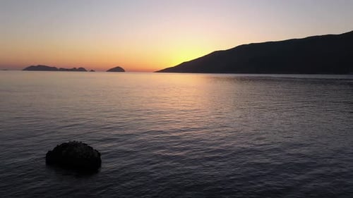 Top View of Calm Sea on the Background of Mountains and Sunset Sky