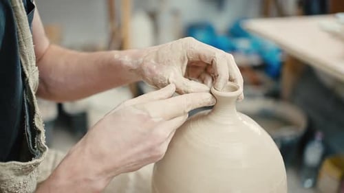 Close Up of Male Potter Hands Forming Neck on Vase Working on Pottery Wheel Tracking Shot Slow