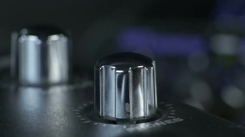 Bouton d'interface audio argenté tournant les doigts féminins