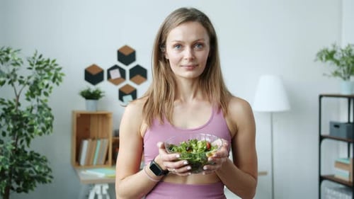 Woman Holding Bowl of Salad in Home Setting