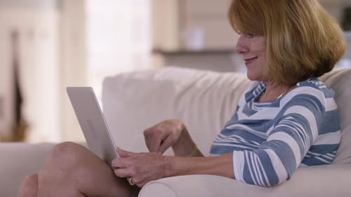 Woman Using Laptop While Sitting in Armchair at Home