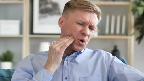 Man Experiencing Toothache with Hand on Face