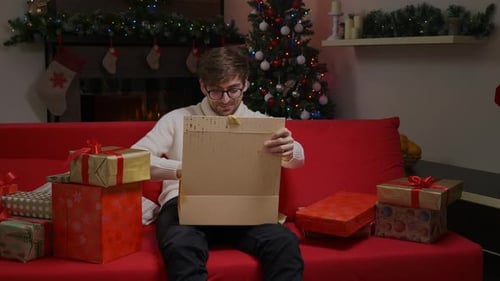 Man Opening Christmas Gift on Couch
