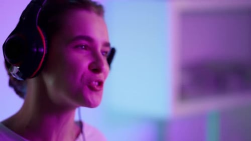 Excited Young Adult Celebrates Gaming Win with Headphones