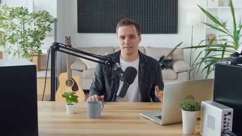 Man Recording Podcast at Desk with Microphone