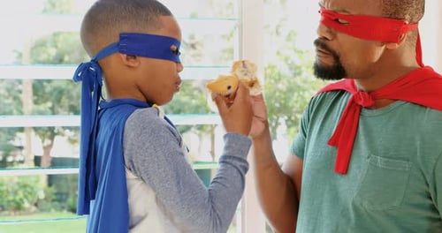 Superhero Dad and Son Eating Cupcakes Indoors