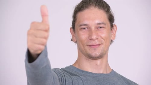 Gesicht eines glücklichen Mannes, der lächelt und Daumen hoch gibt
