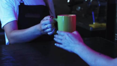 Bartender Handing Coffee Mug to Customer