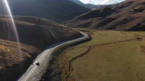 Aerial View of Car Driving Through Mountain Road