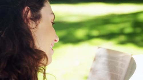 Beautiful woman reading book in garden