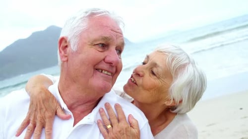 Senior couple embracing each other on the beach