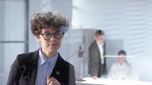 Caucasain Businesswoman Using Invisible Multi-Touch Screen on Glass Wall