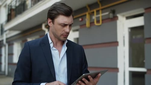 Closeup Business Man Using Tablet at Street. Man Working on Touchpad Outdoors