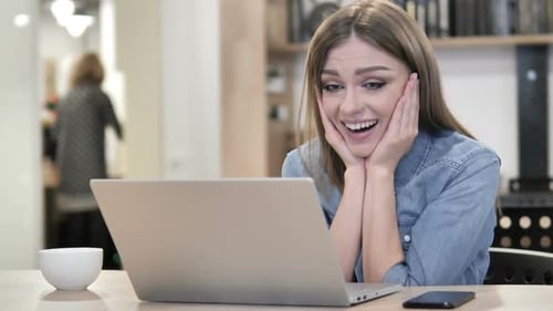 Woman Reacting Happily to Good News on Laptop