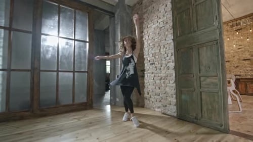 Energetic Young Woman Dancing Freely in Urban Studio