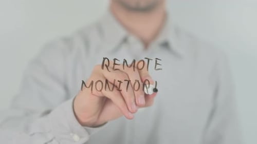 Man Writes 'Remote Monitoring' on Transparent Screen