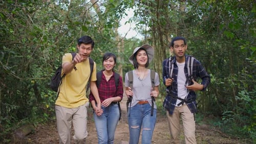 Group of young Asian man and woman friend feel happy, enjoy travel and walk in the forest together.