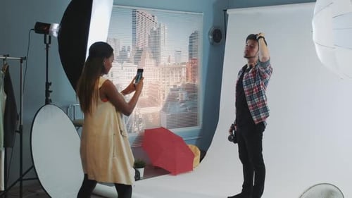 Female Photographer Captures Man With Camera in Studio