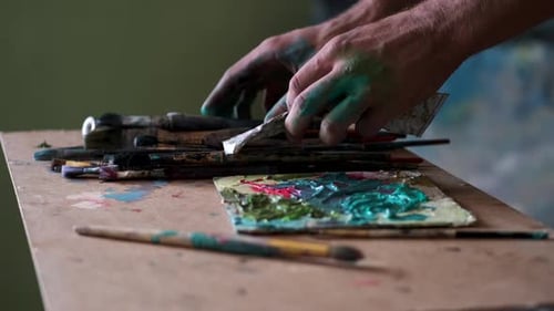 Künstler machen sich bereit zum Malen durch Mischen und Mischen von Farbe