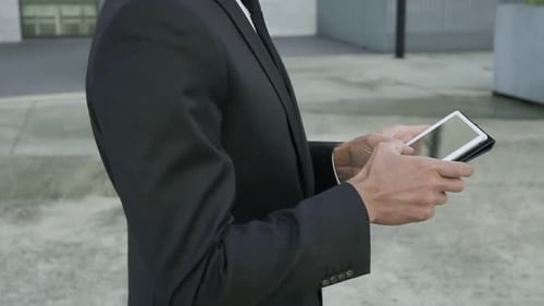 Male Hands Holding Tablet and Man Typing on Touchscreen
