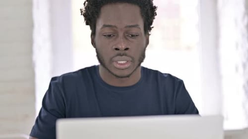 Sick African Man Working on Laptop and Coughing in Office