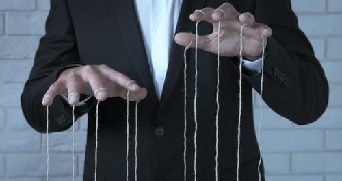 Adult Hands Pulling Puppet Strings Concept
