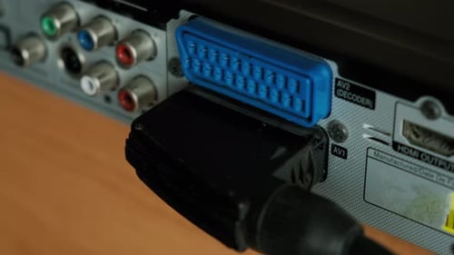 Close Up View of Hand Holding SCART Connector Cable to Disconnect to Device