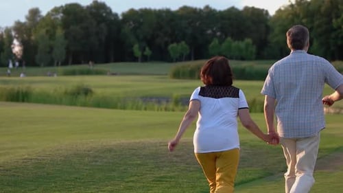 Back View Senior Couple Running Field